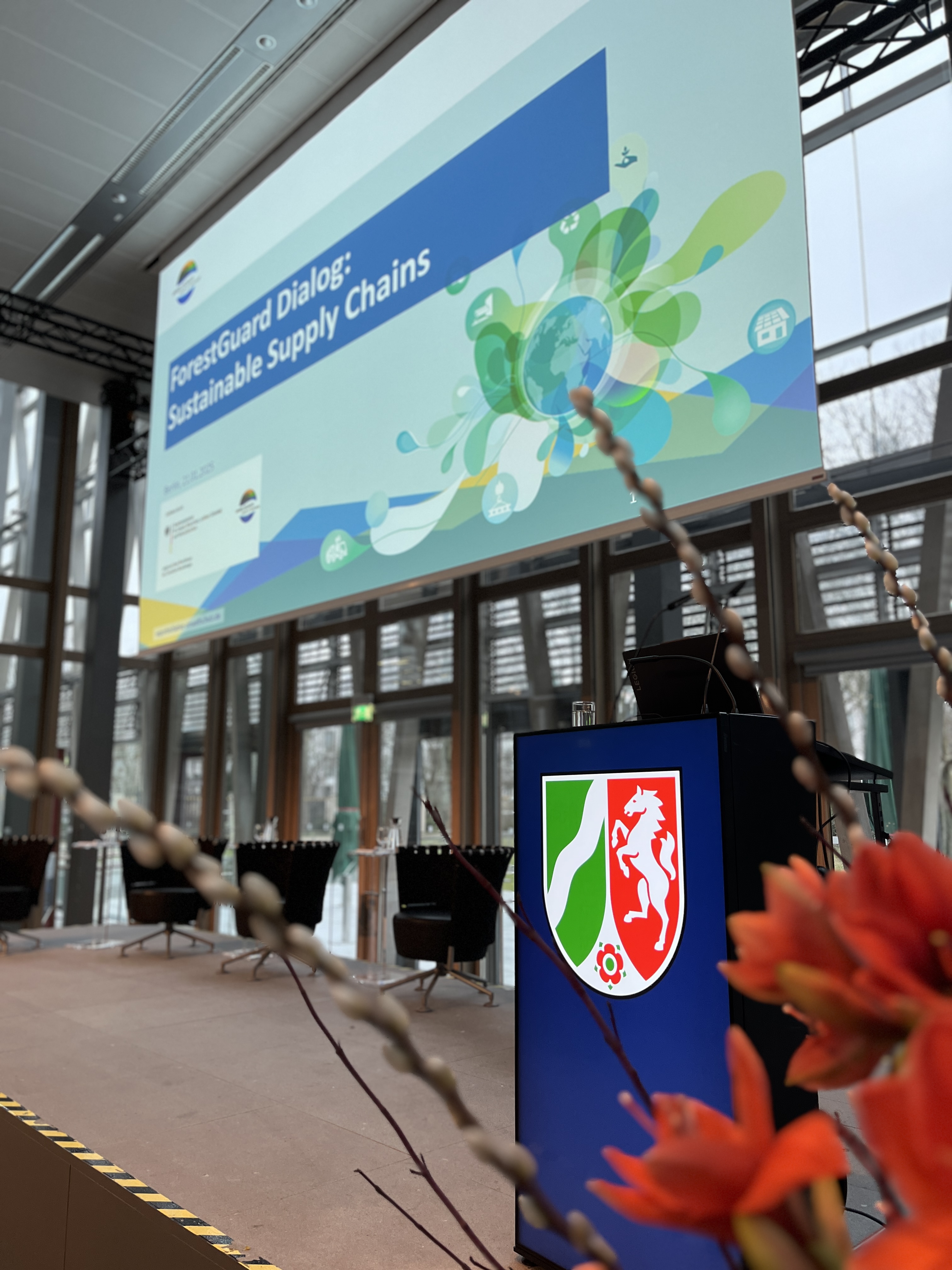 Bühnenbild mit NRW Logo und einer Präsenatation 