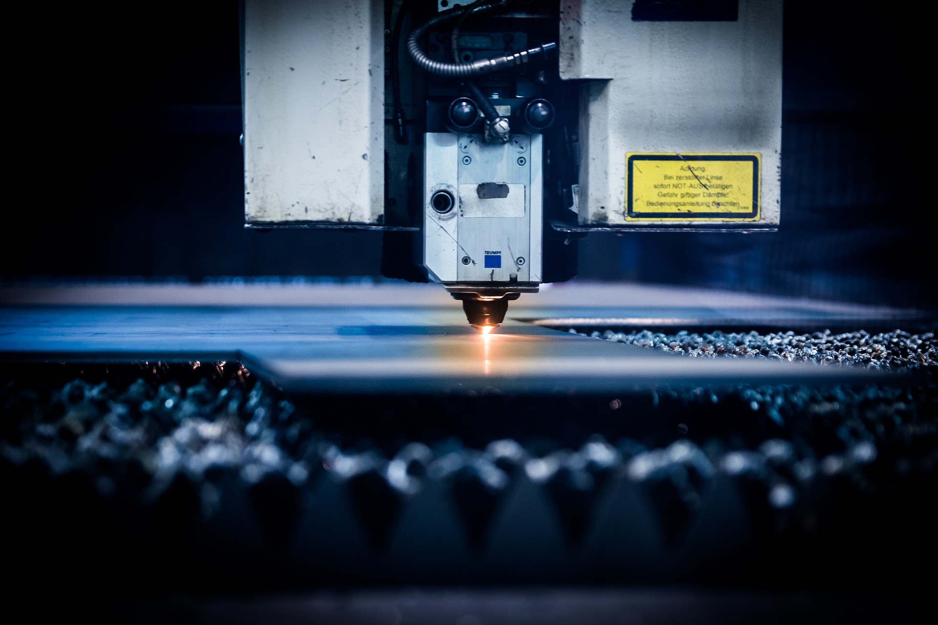 Auf dem Bild ist eine Maschine für das Laserschneiden abgebildet, welche ein Blech schneidet.