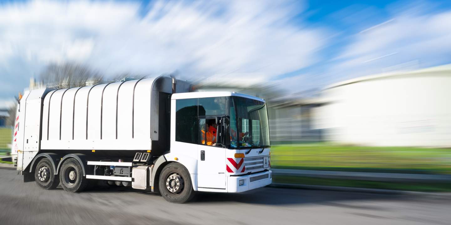 Das Bild  zeigt ein Entsorgungsfahrzeug. Standorte der Entsorgungsbranche sind vielfältig und komplex, oft mit mehreren Funktionen. Logistische Herausforderungen erfordern eine ganzheitliche Optimierung, die infrastrukturelle Gegebenheiten und Verkehrsströme berücksichtigt.
