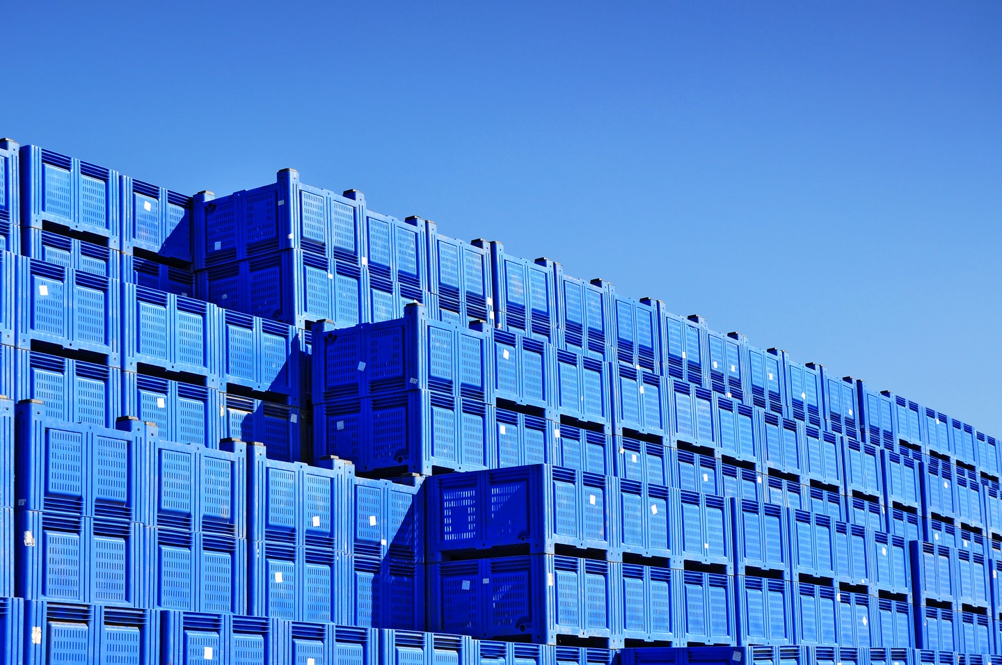 Das Bild zeigt gestapelte gebrauchte Kunststofftransportcontainer. Es soll die Wichtigkeit der Zirkularität in der Kunststoffwirtschaft darstellen. Das Fraunhofer IML forscht mit anderen Instituten und Partnern in diesem Themenfeld.