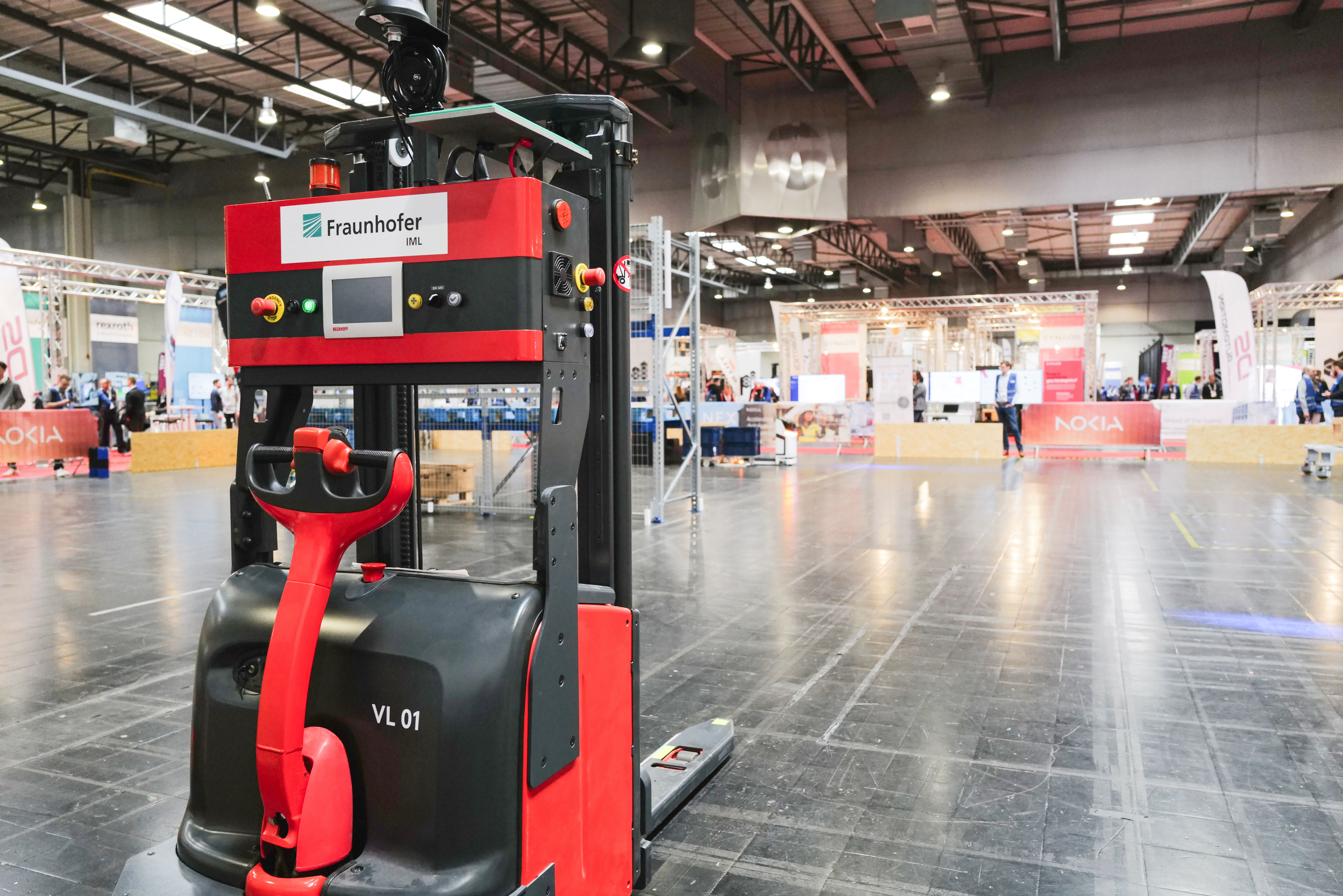 Ein Fahrerloses Transportfahrzeug für Paletten steht in einer Halle.