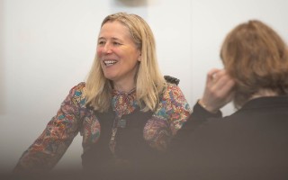 Das Foto zeigt Kerstin Radomski, die ein industrielles Exoskelett trägt
