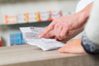 Apotheker erklärt einem Kunden einen Beipackzettel