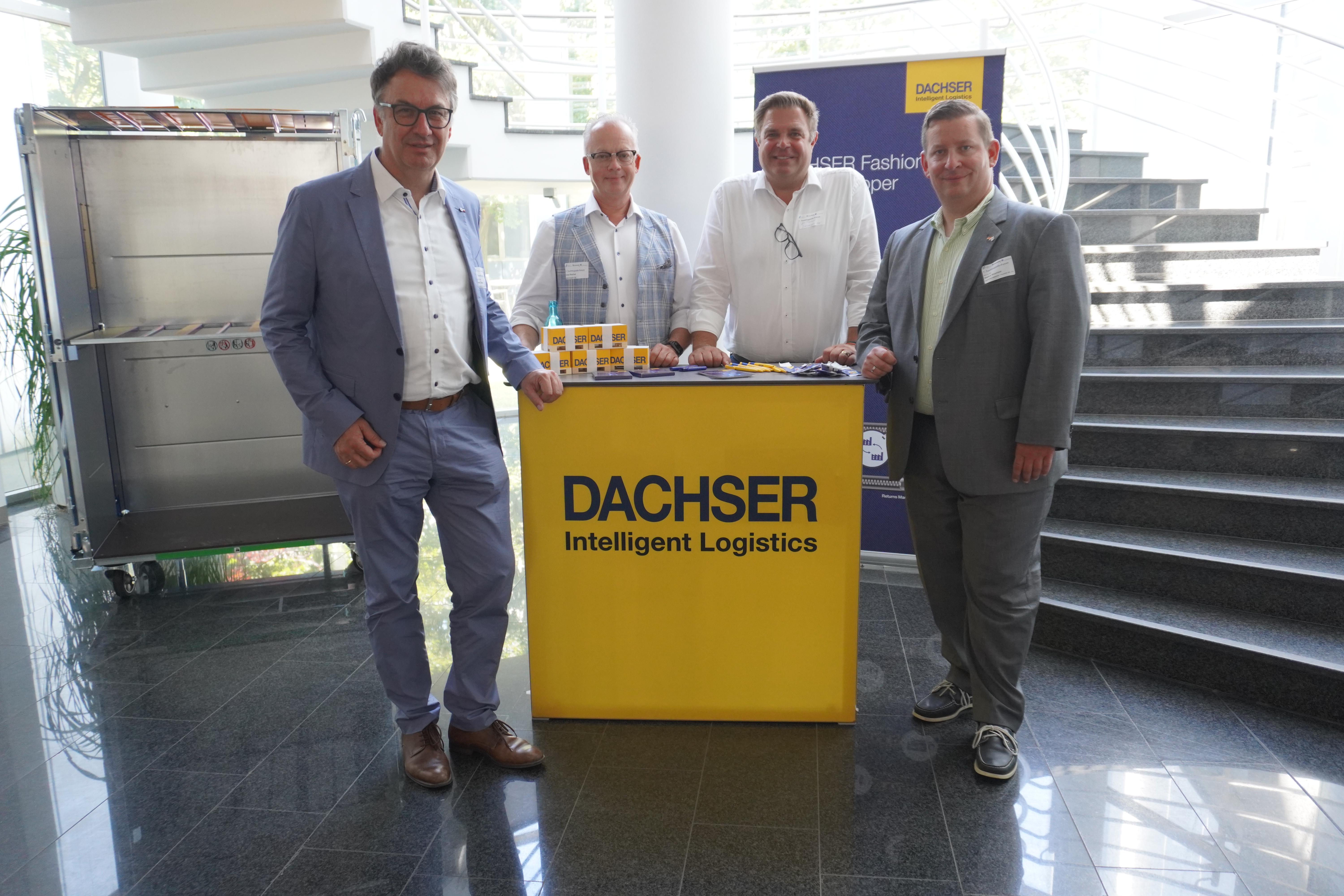 Forum Textillogistik 2025 4 Personen im EIngangsbereich des Fraunhoer IML bei einem Gruppenbild.