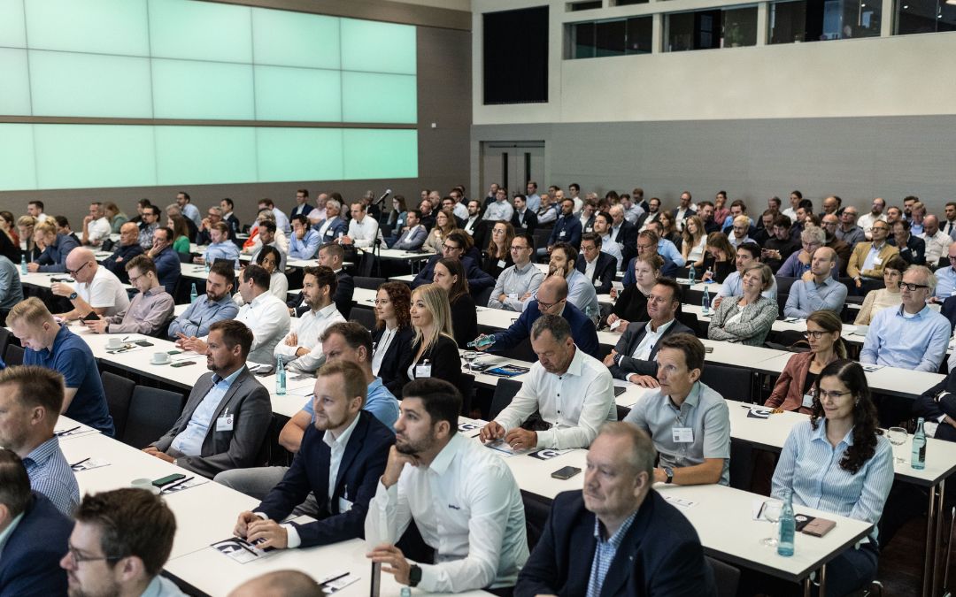 Viele Menschen an Tischen sitzend in einem Kongress