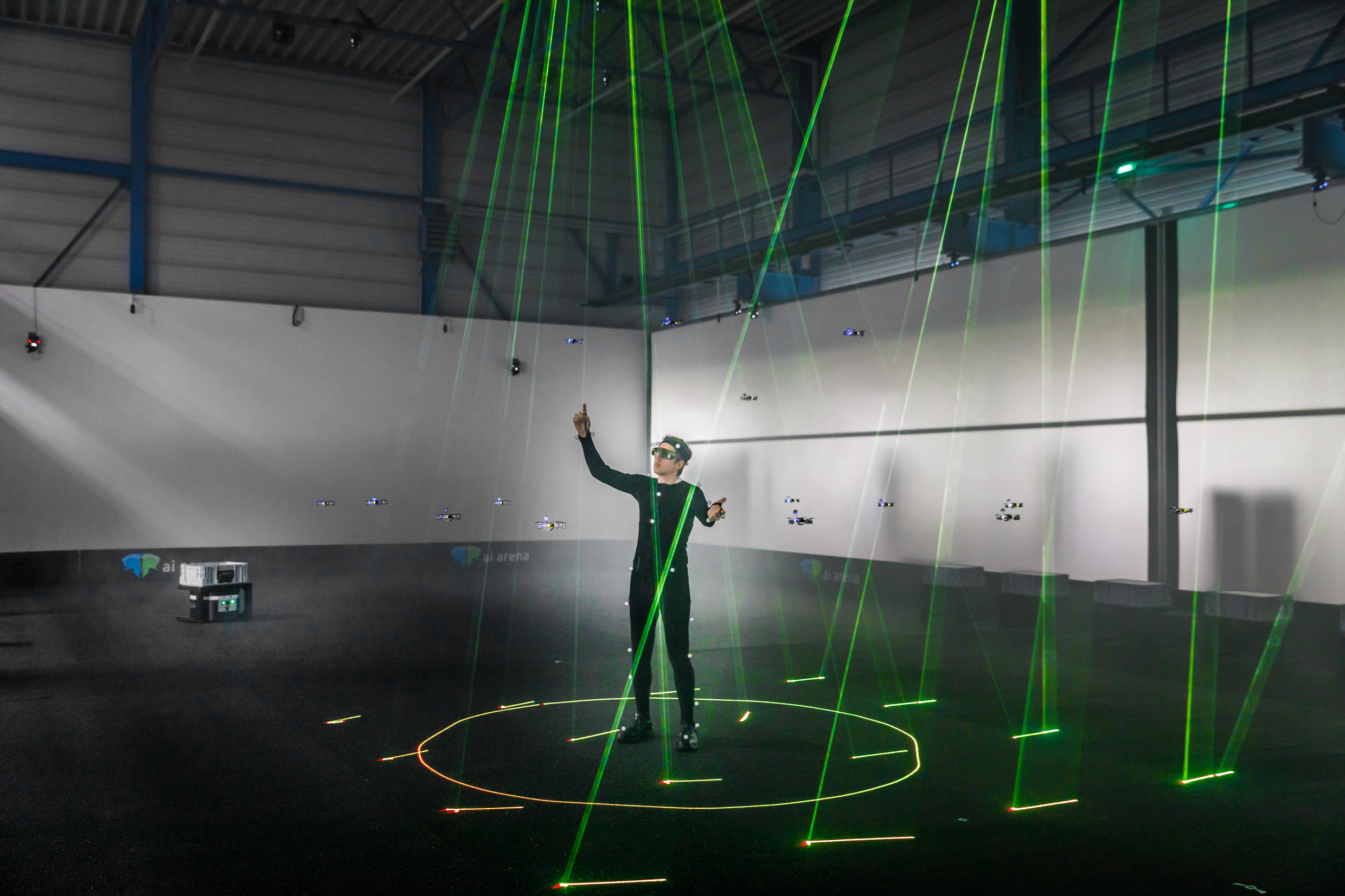 Das Bild zeigt einen Mann in einem Motion Capturing Anzug, umgeben von Lasern.