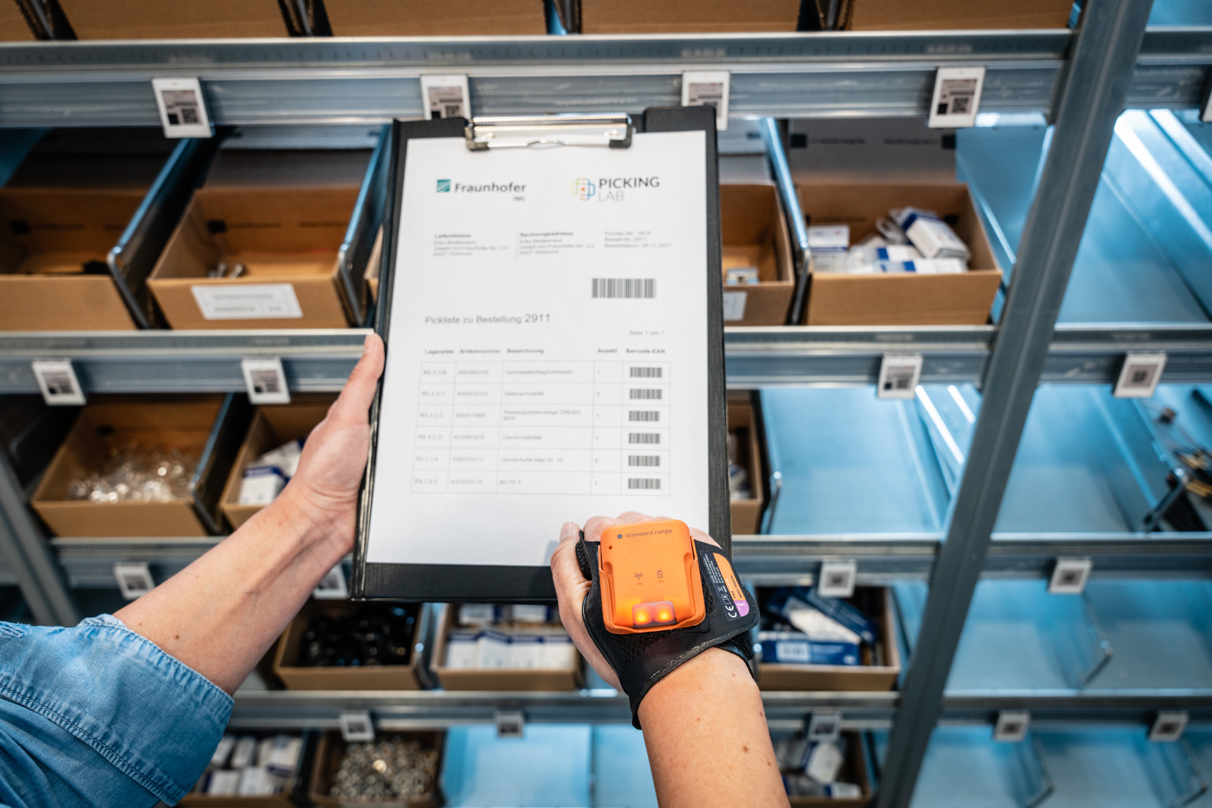 Eine Person nutzt einen Handscanner als Assistenzsystem für die Kommissionierung