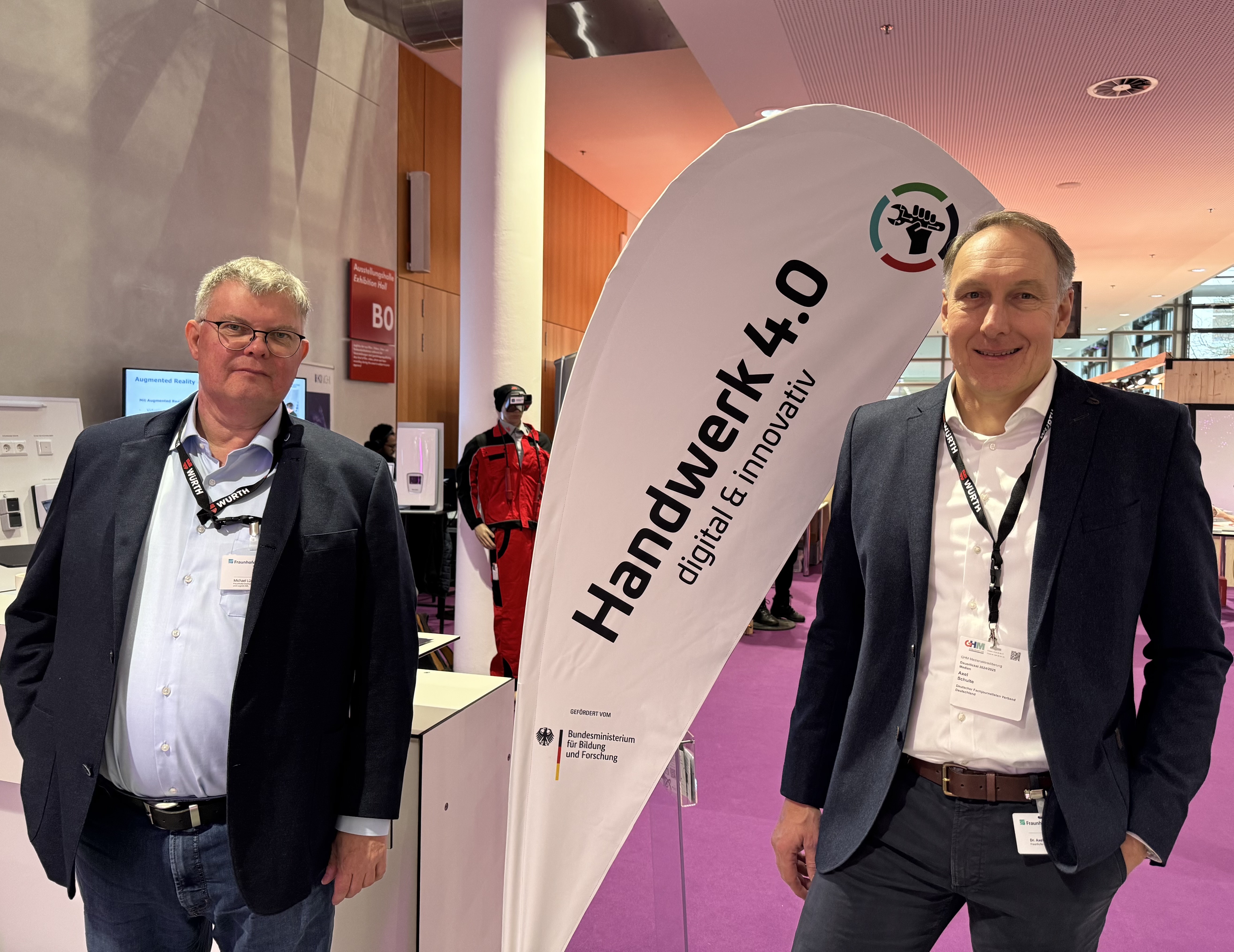 Axel und Michael auf dem Kongress »ZUKUNFT HANDWERK« in München vor einem Aufsteller mit dem Aufdruck Handwerk 4.0 digital & innovativ