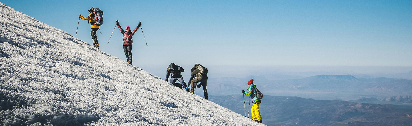 Ein Wanderer steht jubelnd auf einer Bergspitze – Symbol für gemeinsame Ziele, erfolgreiche Teamarbeit und die Kraft guter Organisation. Wie beim Gipfelsturm braucht es auch in der Organisationsentwicklung klare Strategien, Ausdauer und Zusammenarbeit, um neue Höhen zu erreichen.