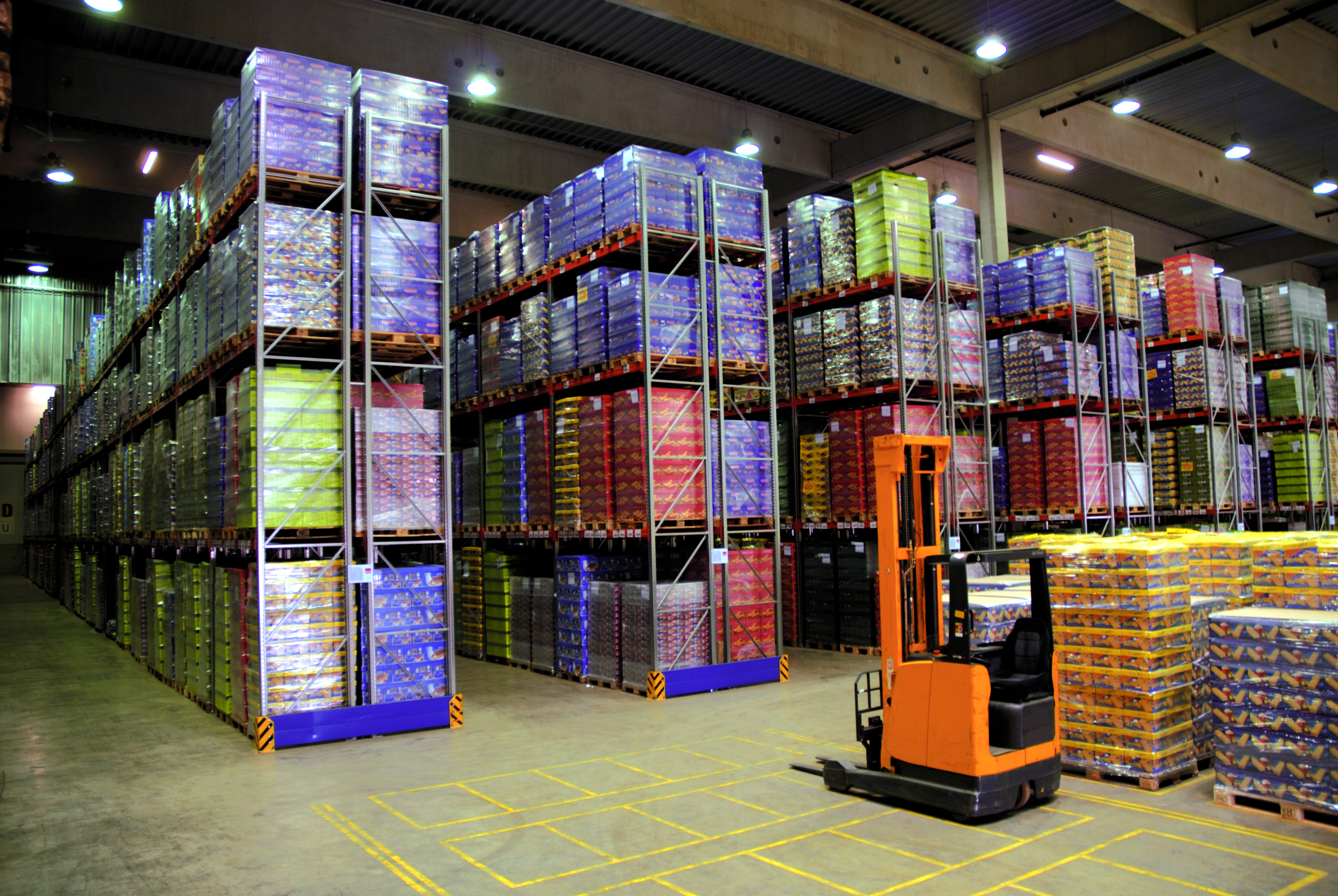 The picture shows a logistics hub with a forklift and shelves. Fraunhofer IML supports by making logistics hubs efficient and optimize transport processes.