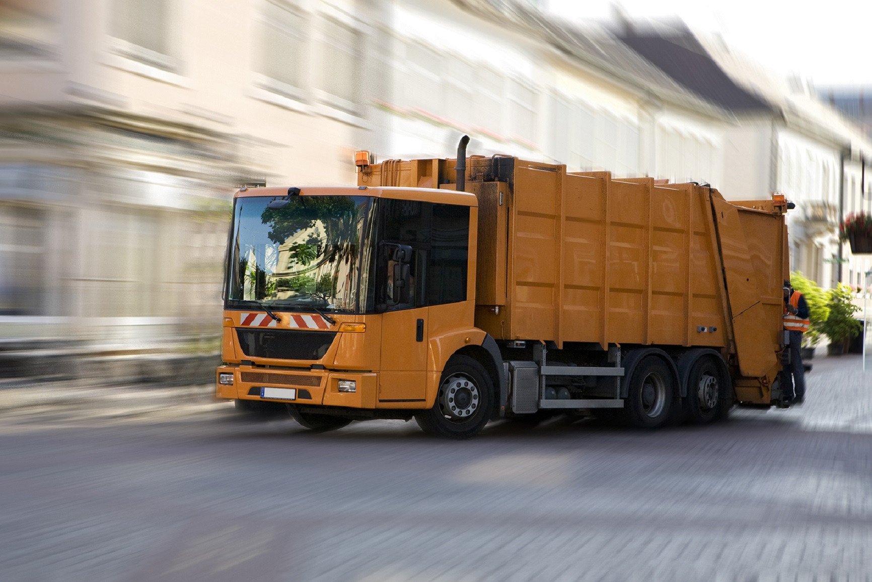 A yellow garbage truck on the road symbolizes Fraunhofer IML's expertise in waste management, sustainability, and logistics. This is highlighted in numerous project examples.