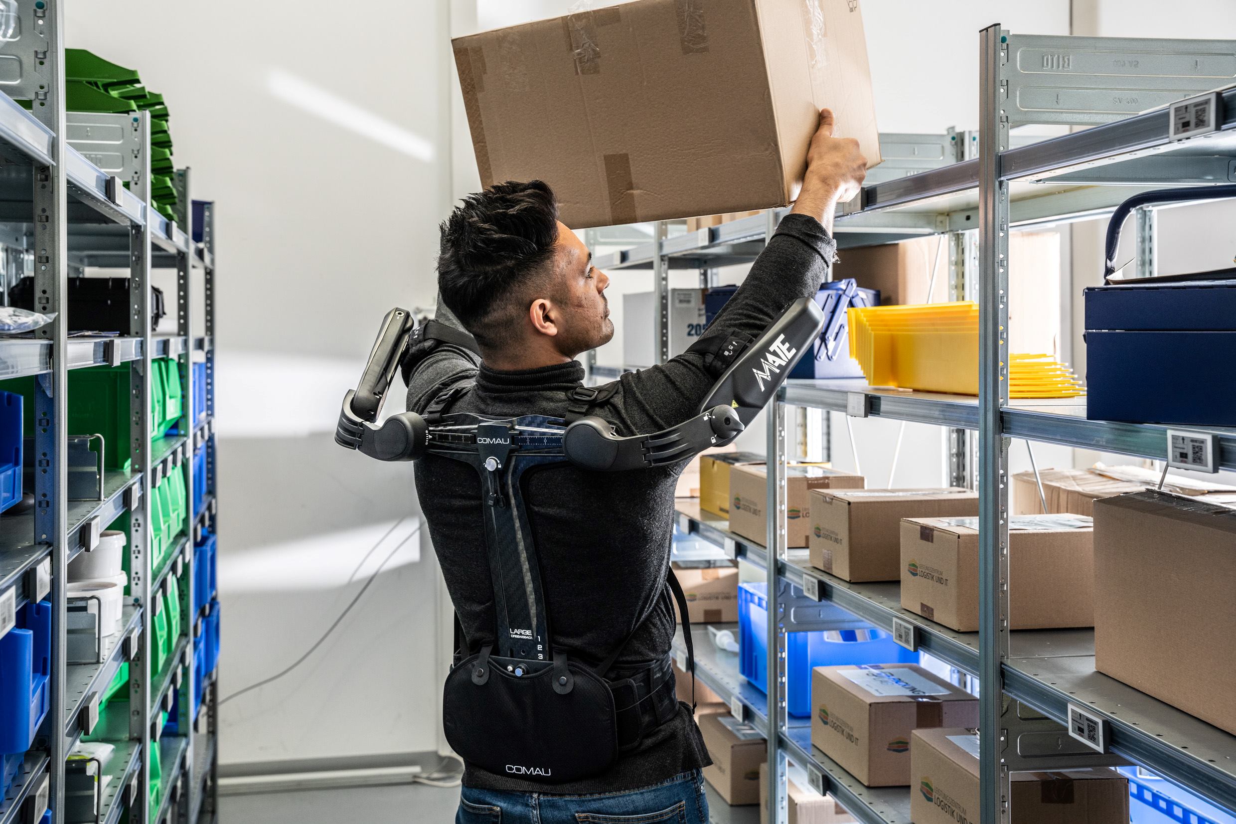 Ein Mann nutzt ein Exoskelett als Unterstützung bei der Arbeit im Lager.