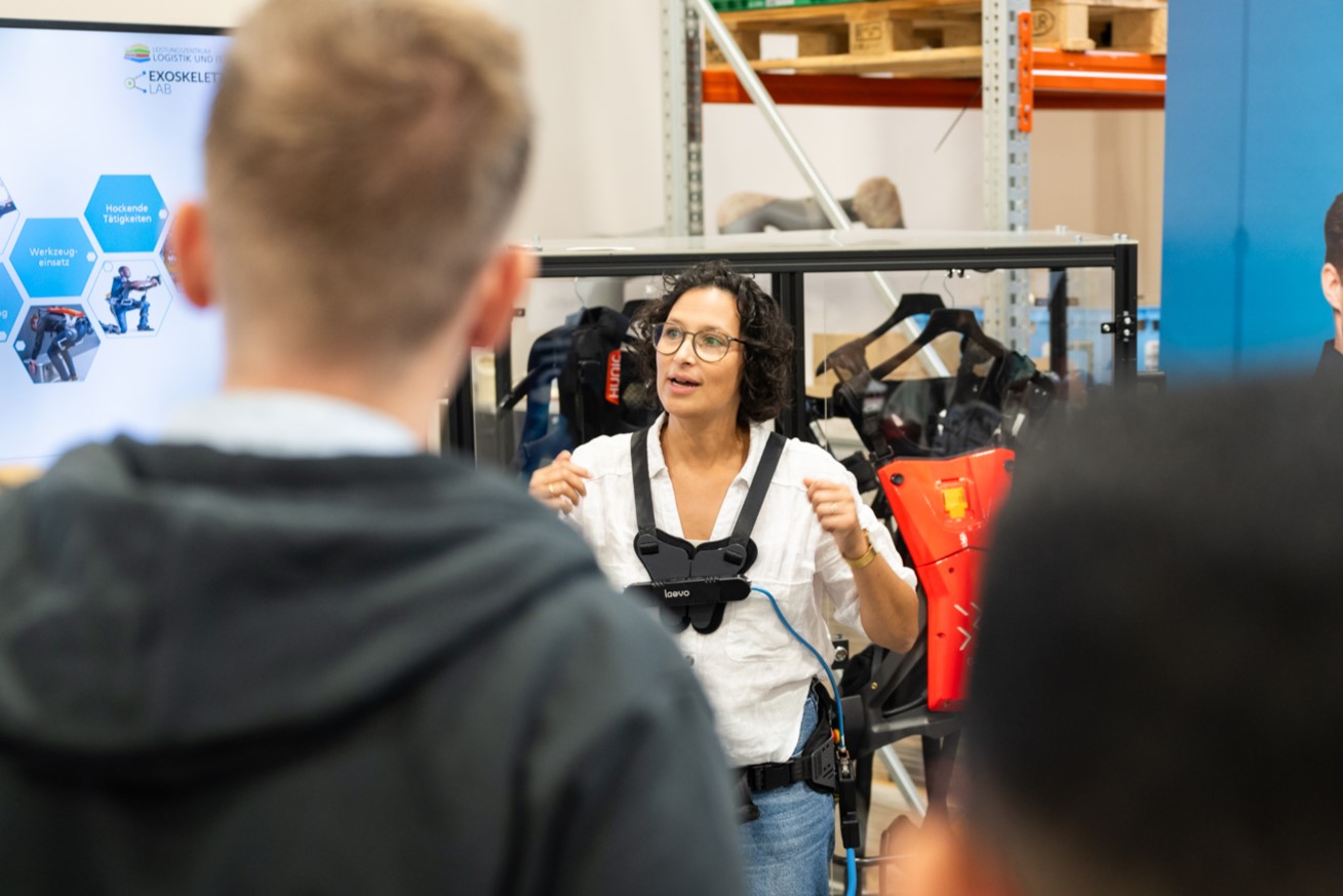 Eine Frau erklärt, wie Exoskelette für die Industrie funktionieren.