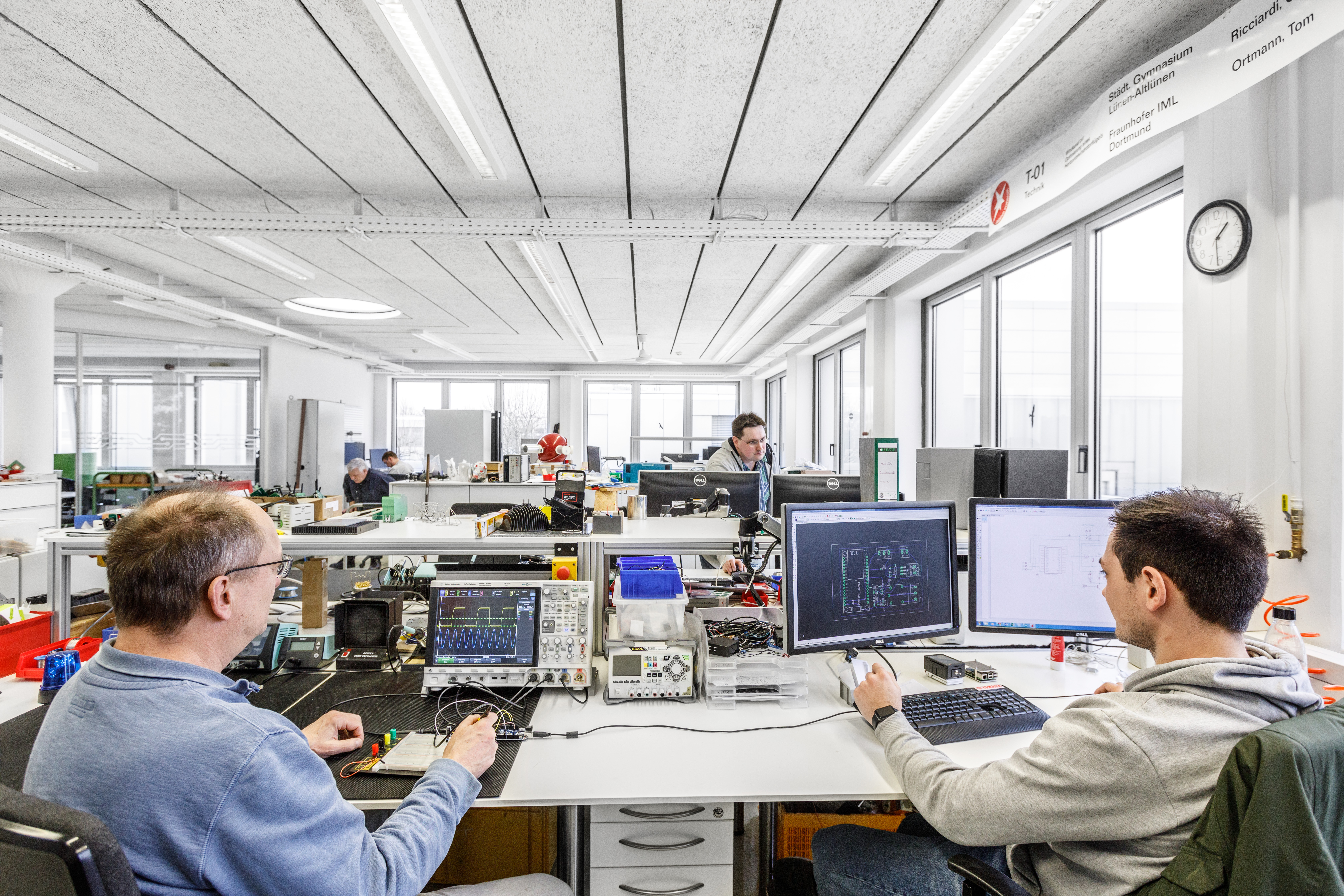 Mitarbeitende arbeiten im E-Labor an der Verkabelung.