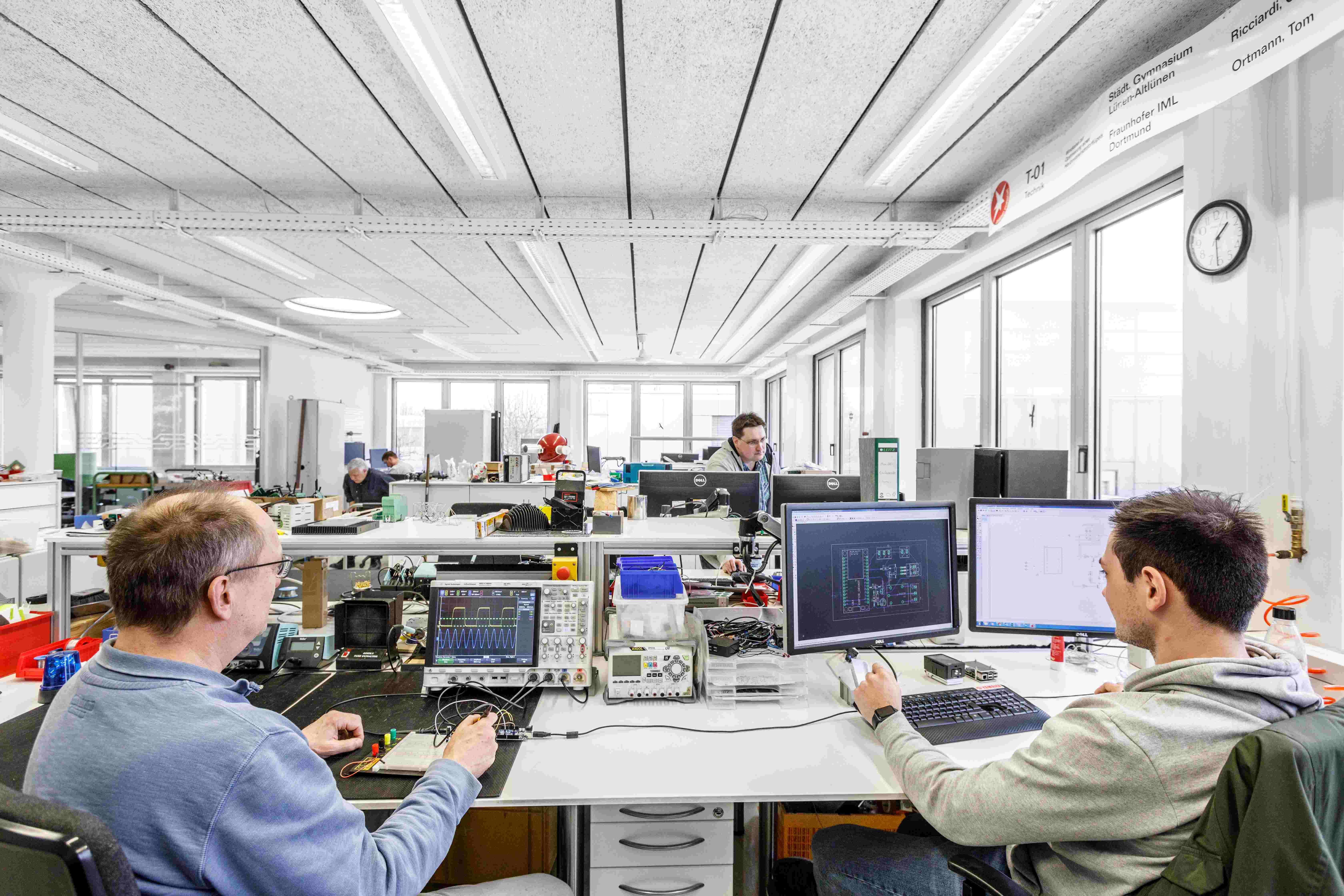 Mitarbeitende arbeiten gemeinsam im E-Labor an Innovationen.