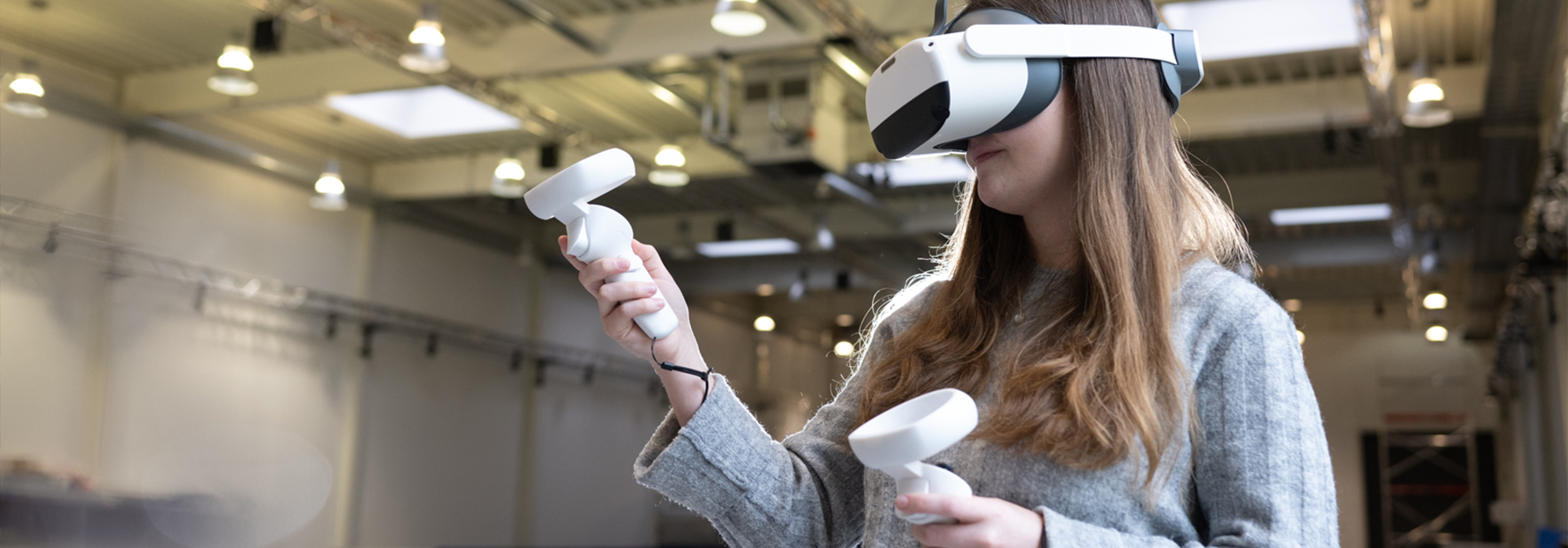 XR Lab Forschungshallen Eine Frau mit einer Augmented Reality Brille und Controllern