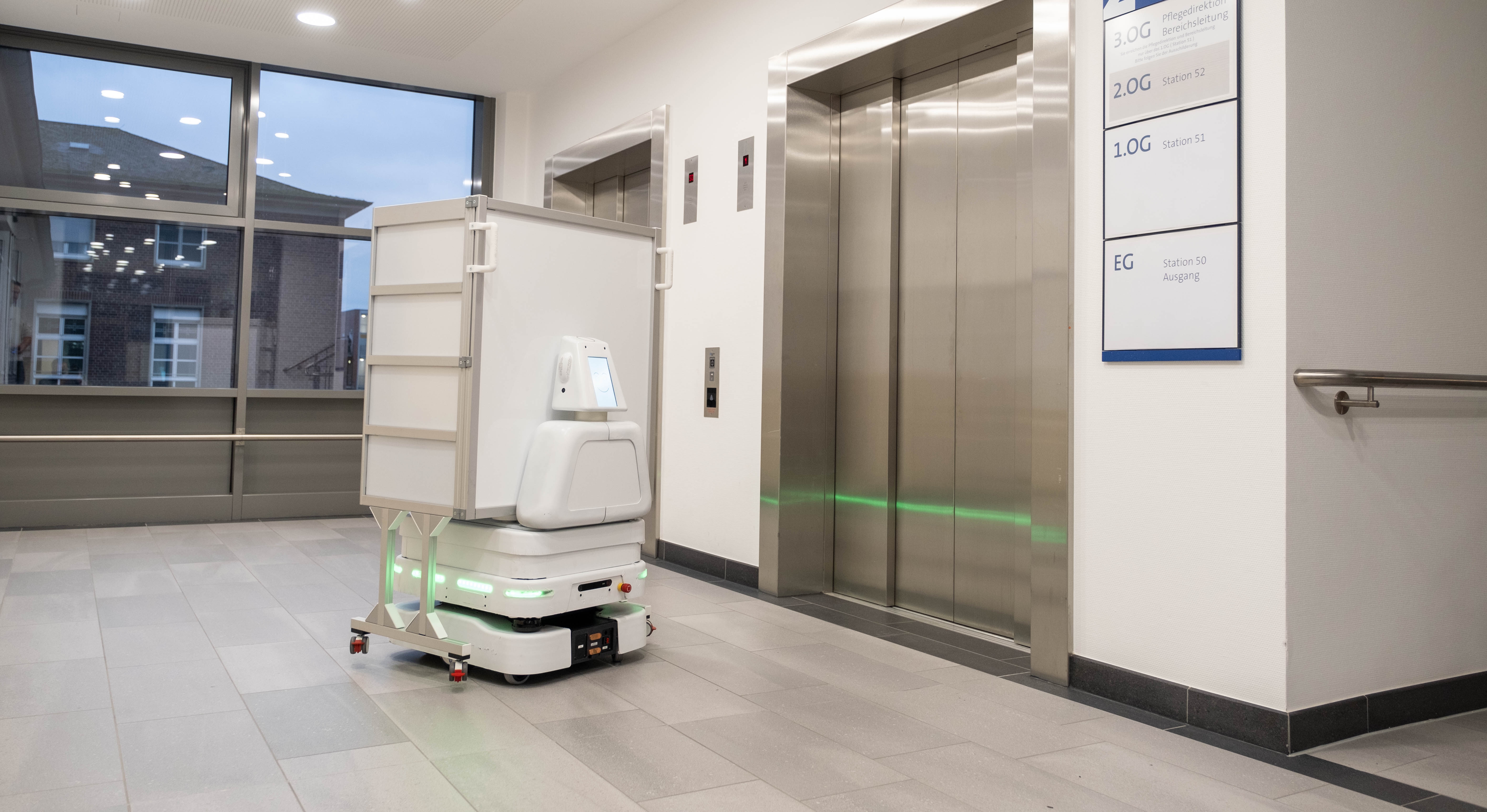 Der Transportroboter RemRob steht an einem Aufzug im Krankenhaus.