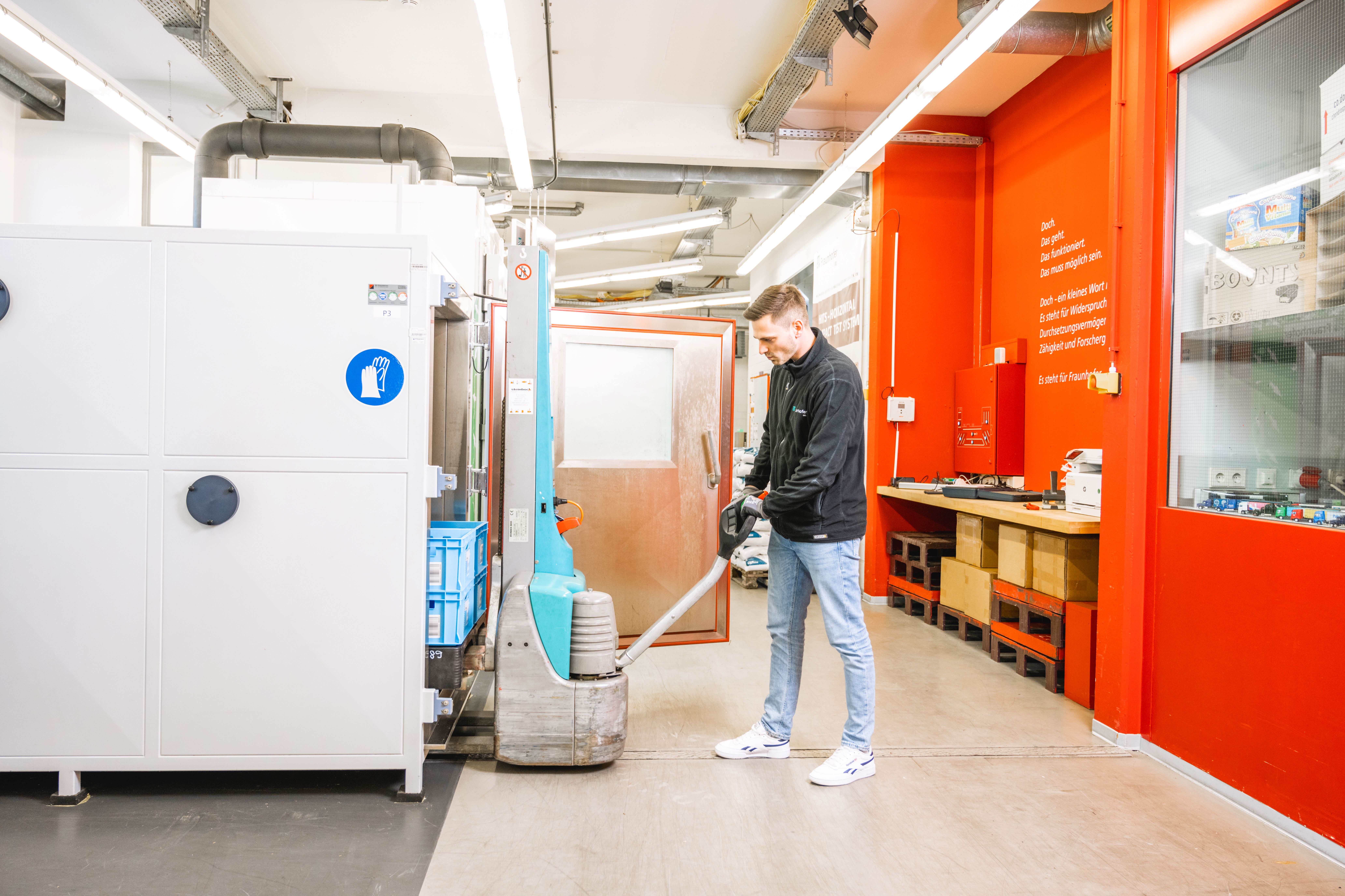 A man transfers paletts into a climate chamber.