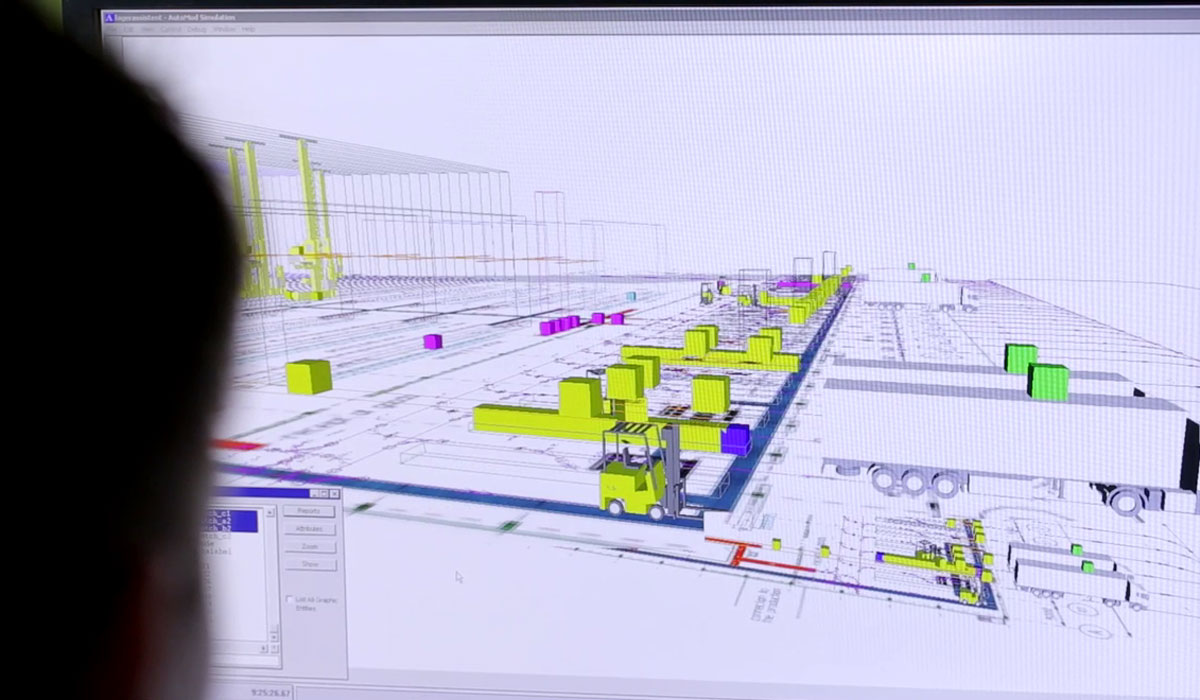 The picture shows a computer-aided simulation of a logistics centre with coloured blocks representing various objects and vehicles.